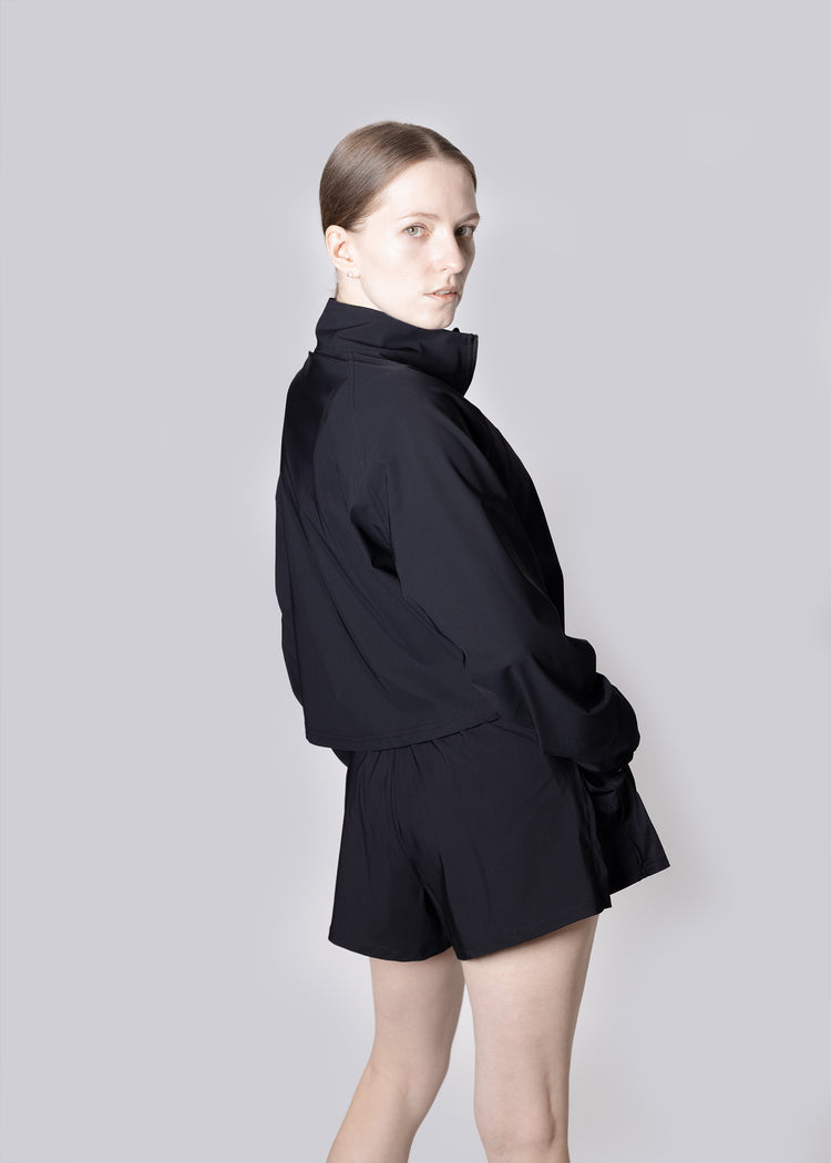 A girl wearing a black outfit on a plain background