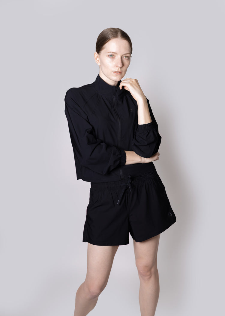 Person wearing a black outfit on a plain background