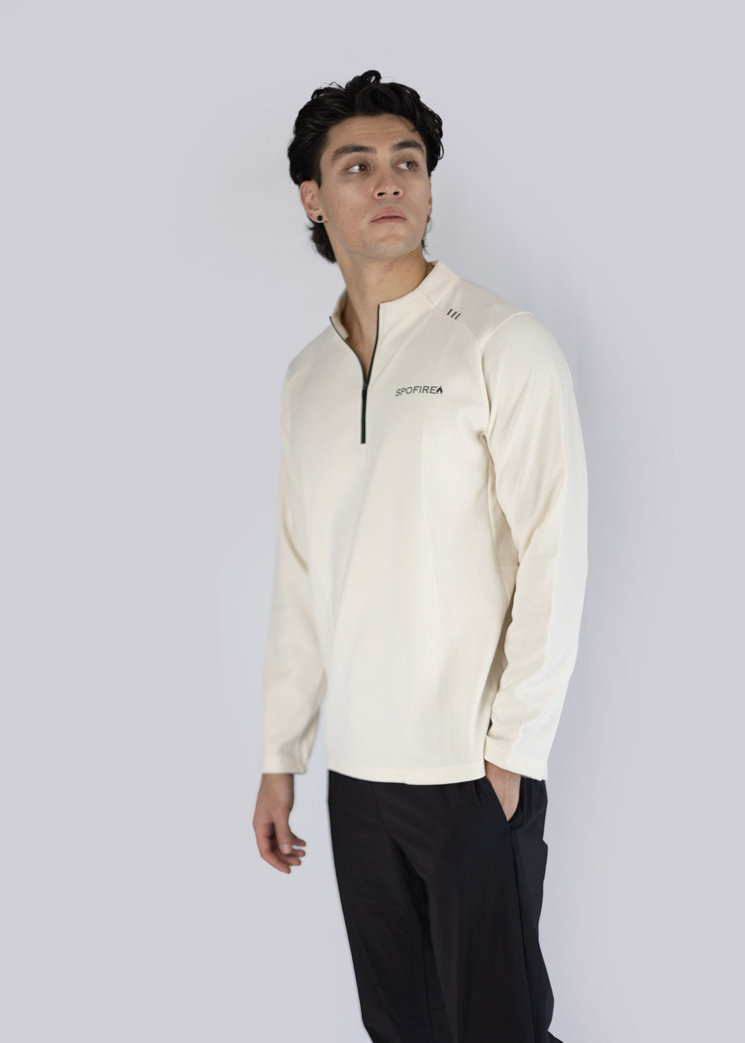 A man wearing off white long-sleeve shirt with spofire logo on a white background