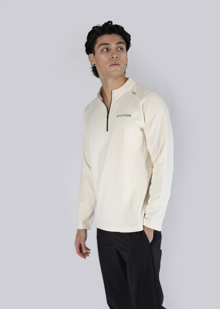 A man wearing off white long-sleeve shirt with spofire logo on a white background