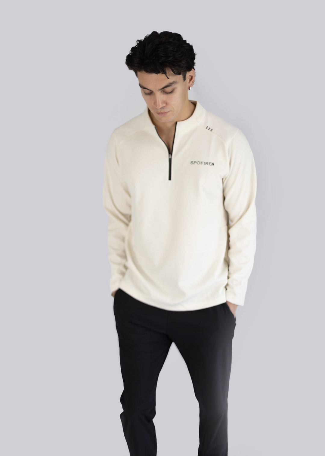 A man wearing a white sweater with the Spofire logo on a light gray background