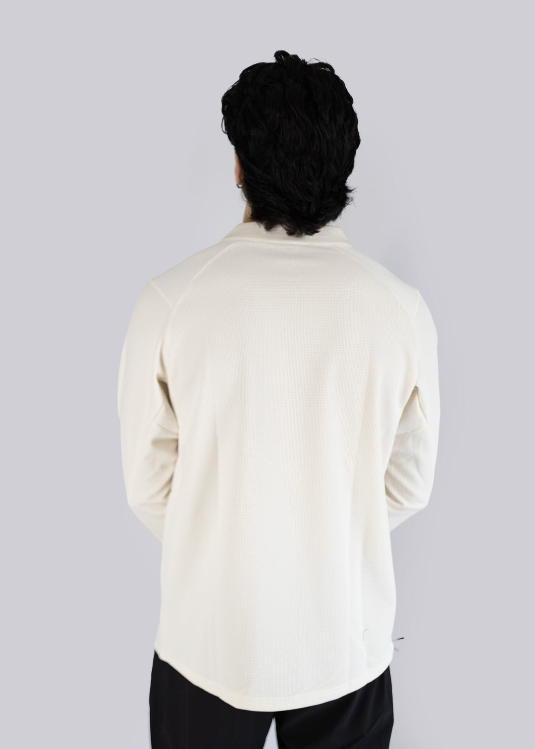 A model wearing off white sweater against a plain background